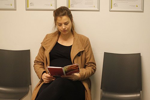 Vrouw lees brochure in wachtkamer