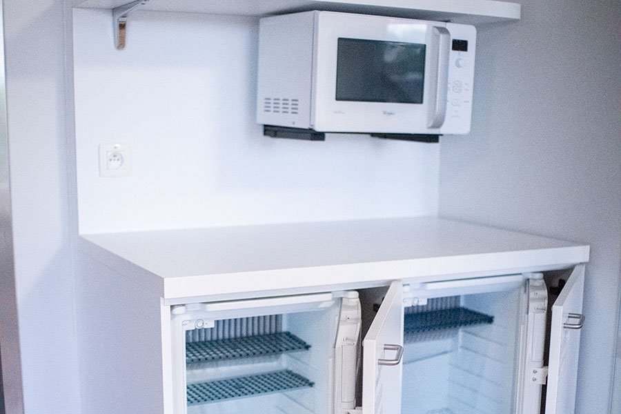 De koelkastjes en de microgolfoven van een tweepersoonskamer op de materniteit in GZA