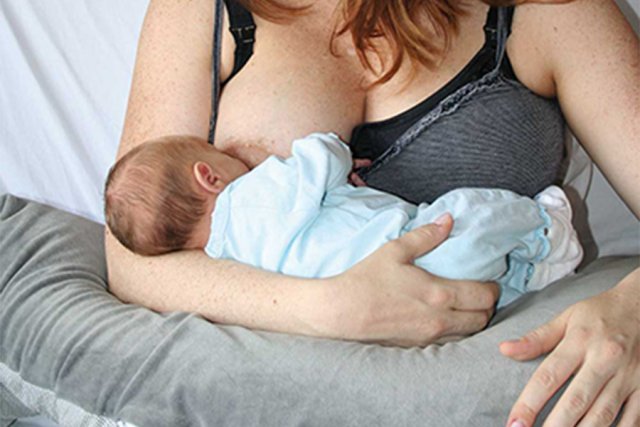 Vrouw geeft haar pasgeboren kind borstvoeding
