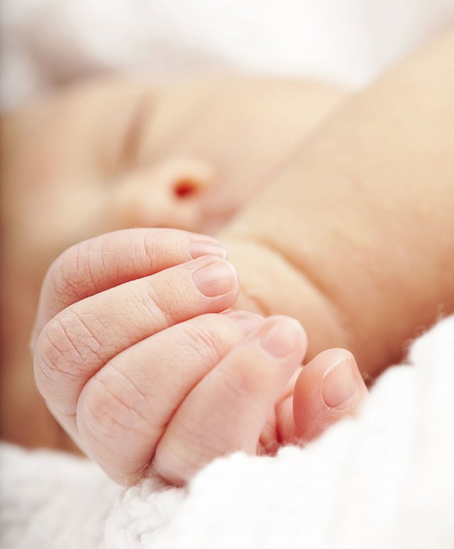 De hand van een pasgeboren baby